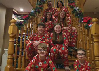 Die Familie sitzt mit Weihnachts-Schlafanzügen auf der Treppe  | © Venke 