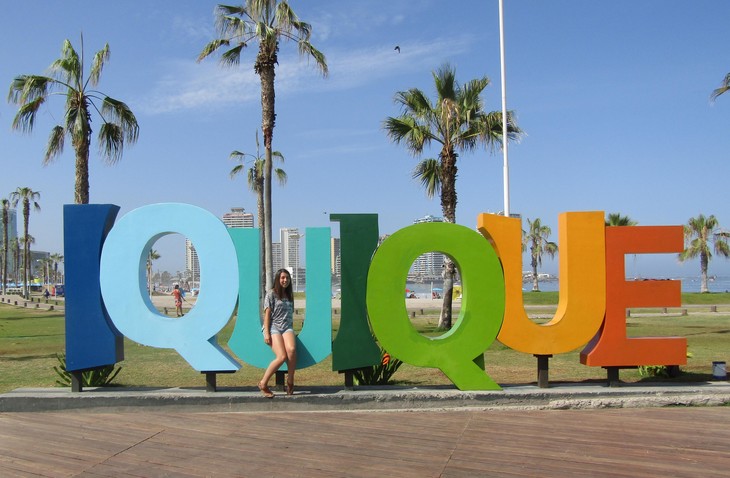 Lea steht vor einem Bunten Iquique-Schild  | © Lea Caruana