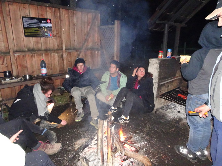 Personen sitzen um das Lagerfeuer herum  | © Luise Bachtler