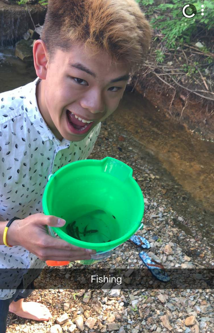 Nam hält einen Eimer mit kleinen Fischen drinnen in den Händen | © Nam Nguyen