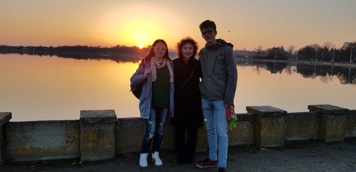 Gruppenbild auf einer Brücke mit Sonnenuntergang im HIntergrund  | © Timon Baral