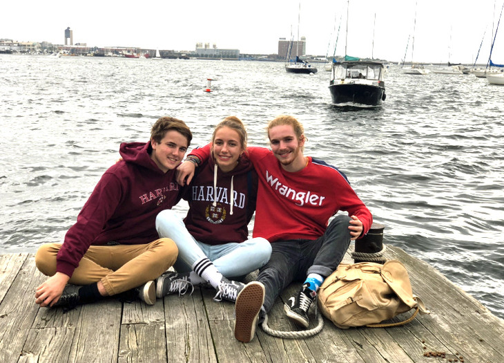 drei Personen sitzen auf einem Steg am Wasser  | © Leandra Ebel