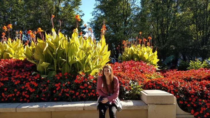 Elif sitzt vor großen, blühenden Blumen  | © Elif Frank