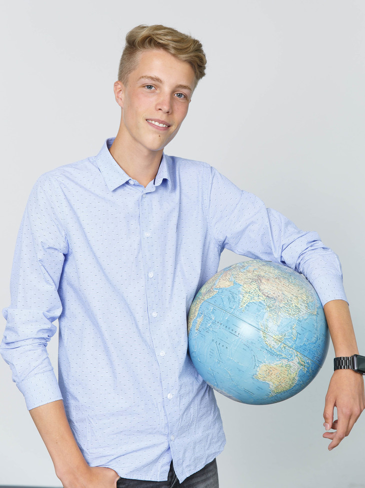 Tim hält einen Globus in den Händen  | © MRN GmbH