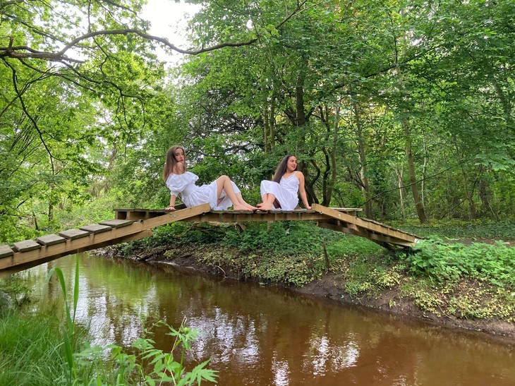 2 Mädchen sitzen auf einer Holzbrücke | © Lena Frohn