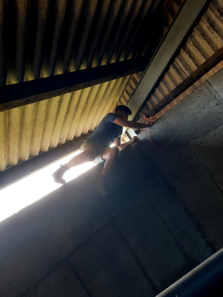 Person sitzt auf einer Mauer unter dem Dach  | © Mathis Schlüchtermann