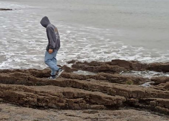 Person läuft über Felsen am Meer  | © Lando Roth 